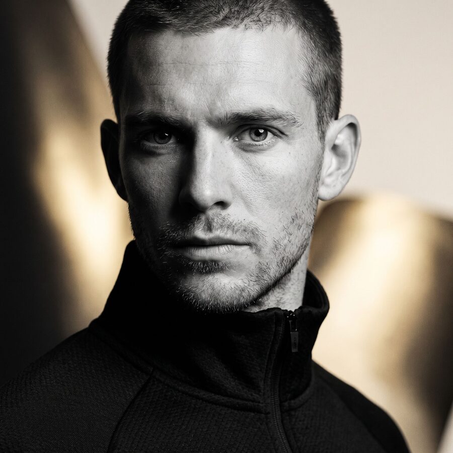 Close-up black-and-white portrait of an athlete in a zip-up jacket