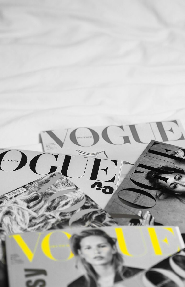 Fashion magazines spread out on white sheets